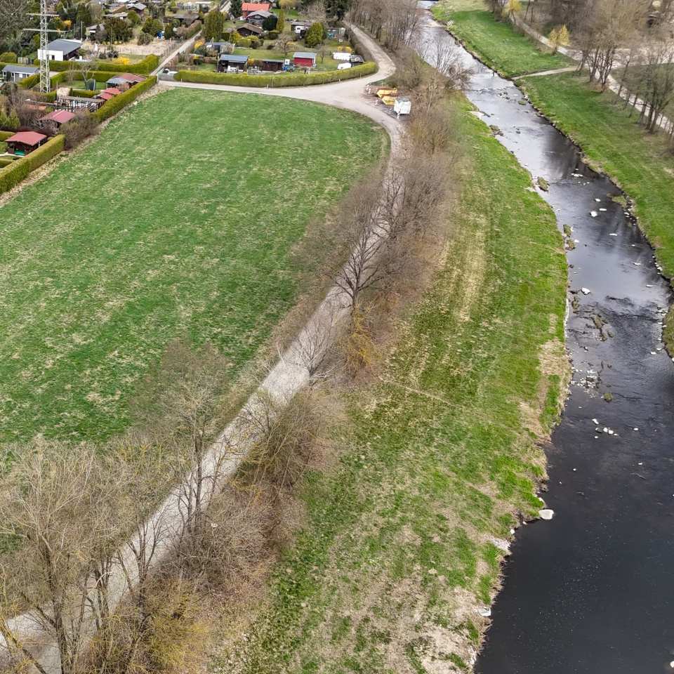 Grünes Feld neben Flussufer